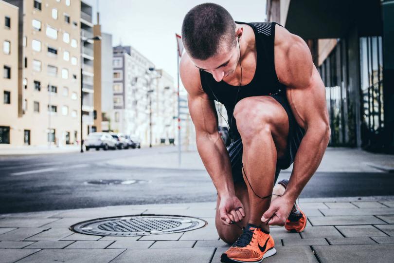 Un coureur qui fait ses lacets